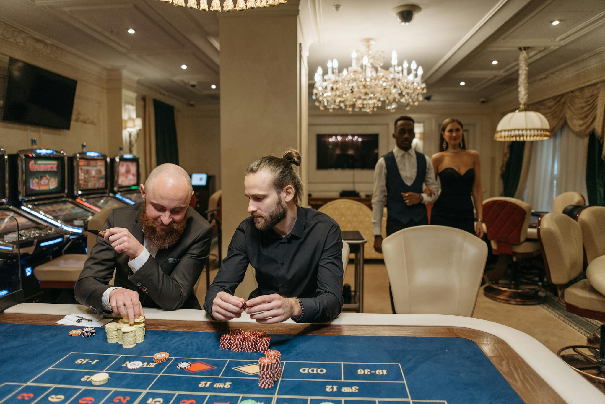 Elegant gamblers enjoy a night at the casino roulette table surrounded by luxury.