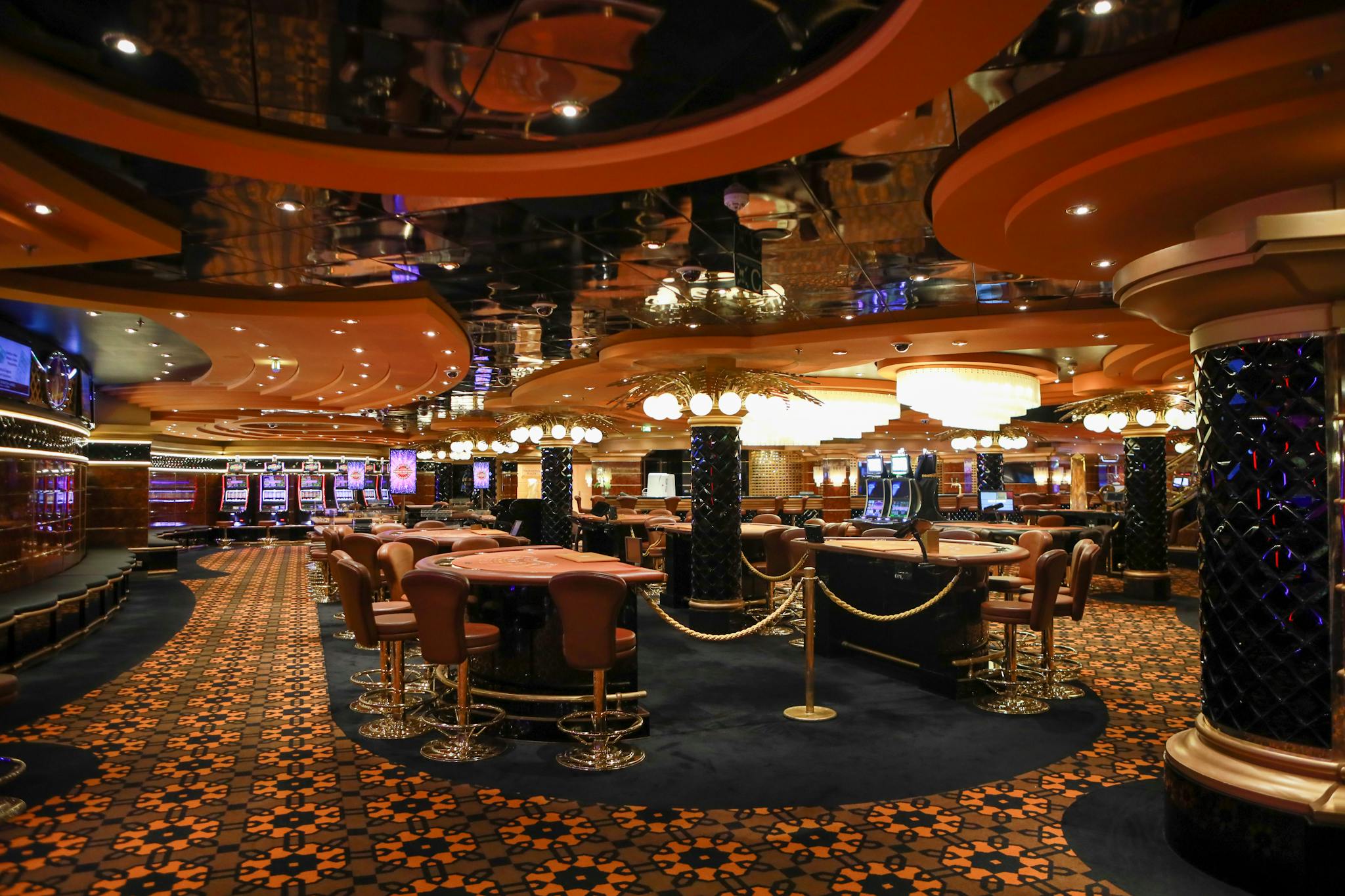 Lavish casino interior featuring slot machines and elegant furnishings under soft lighting.