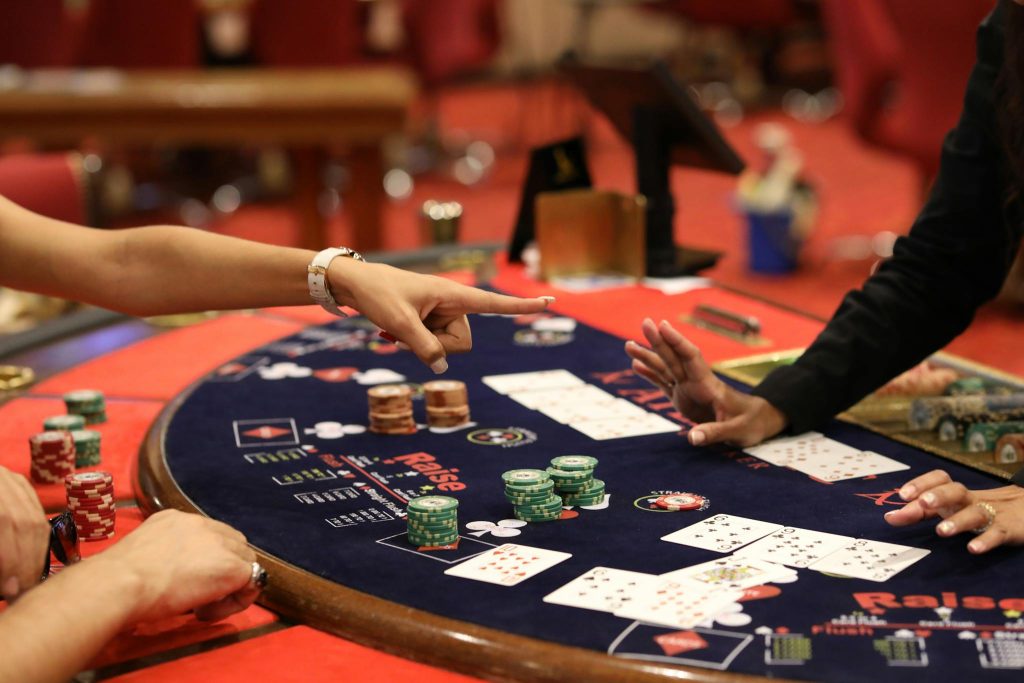 Players engage intensely in a poker game at a casino in Casablanca with cards and chips on the table.